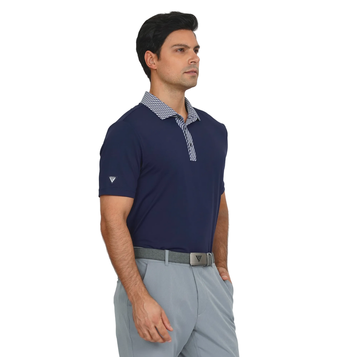 Man wearing a Levelwear navy blue polo shirt with a patterned collar and gray pants on a light gray background