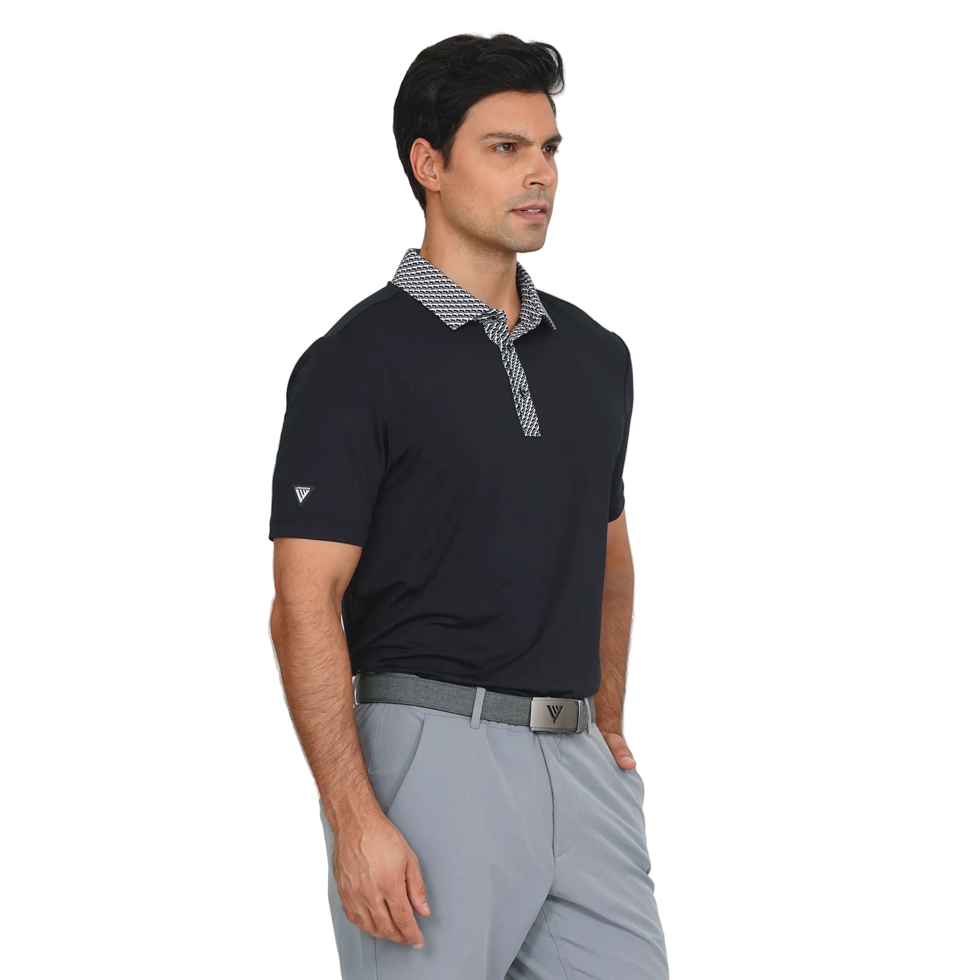 Man wearing a Levelwear black polo shirt with patterned collar and gray pants on a light gray background