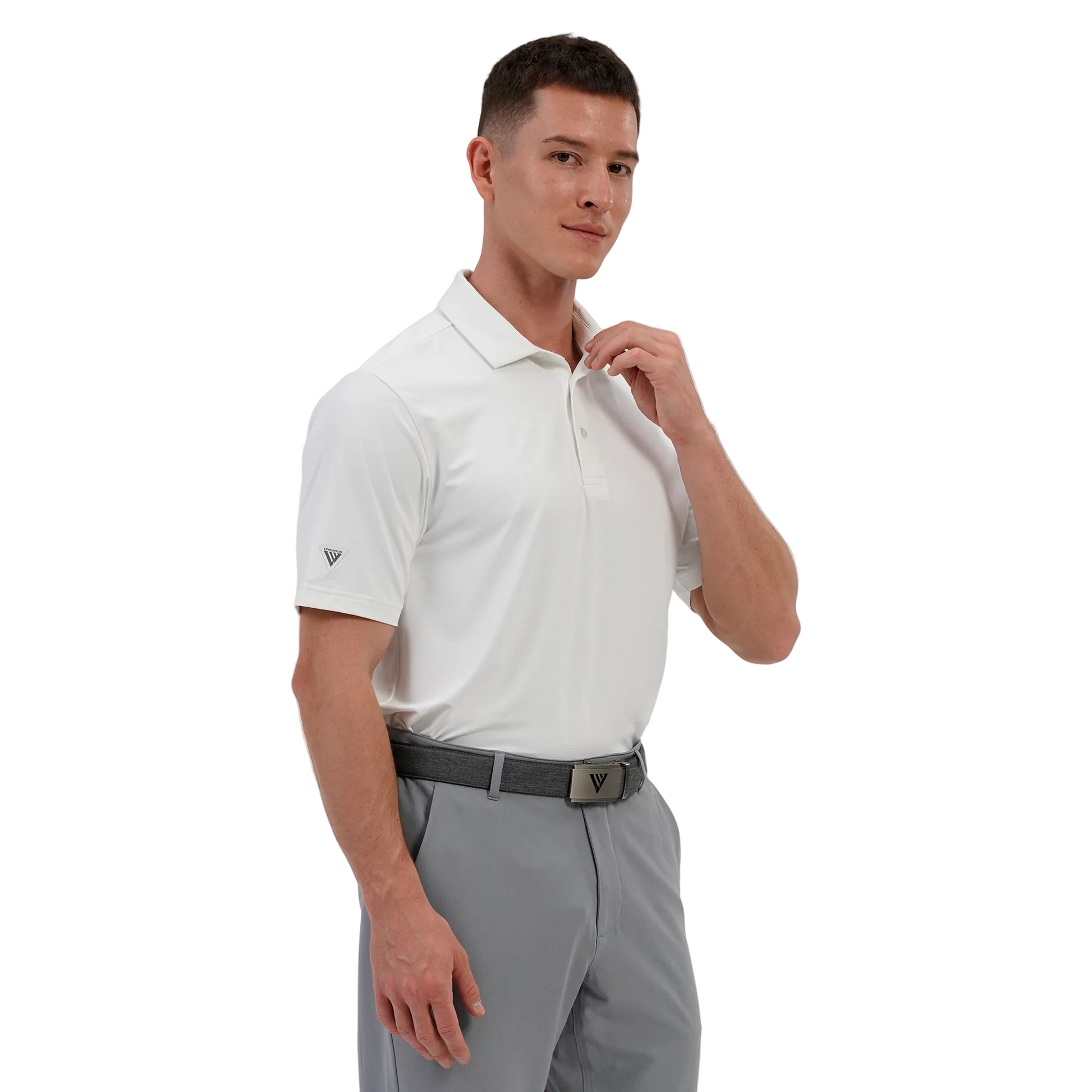 Man wearing a Levelwear white polo shirt and gray pants on a light gray background